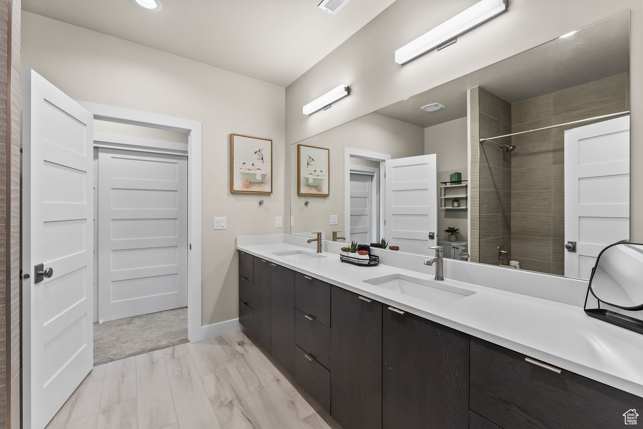 Bathroom with oversized vanity, hardwood / wood-style flooring, and double sink