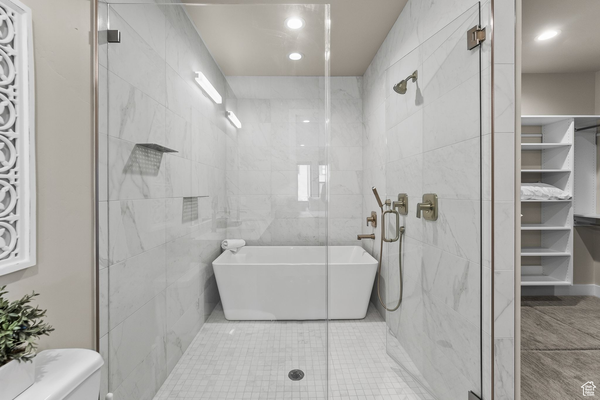 Bathroom featuring tile walls, tile floors, toilet, and separate shower and tub