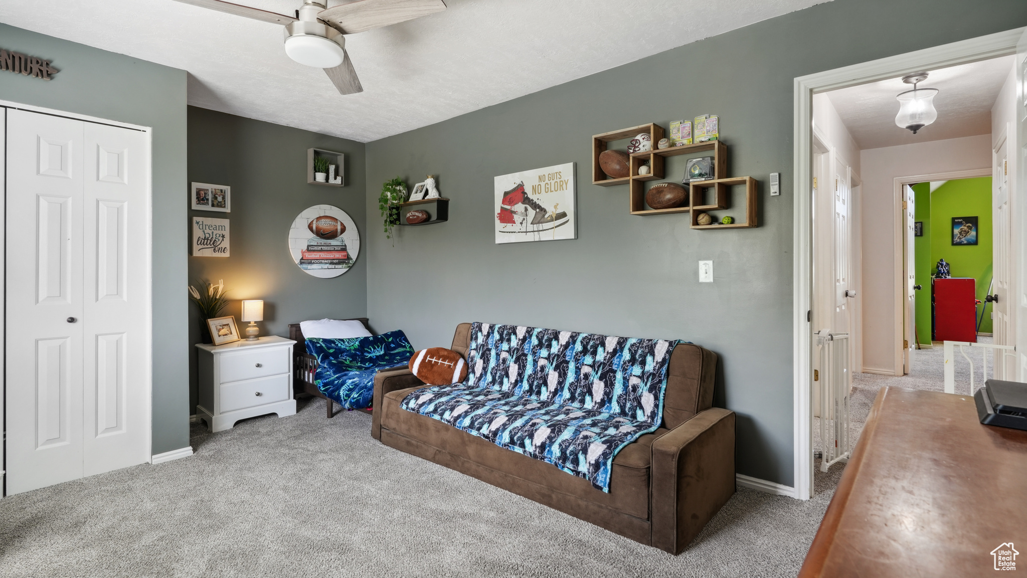 Living area featuring ceiling fan and carpet