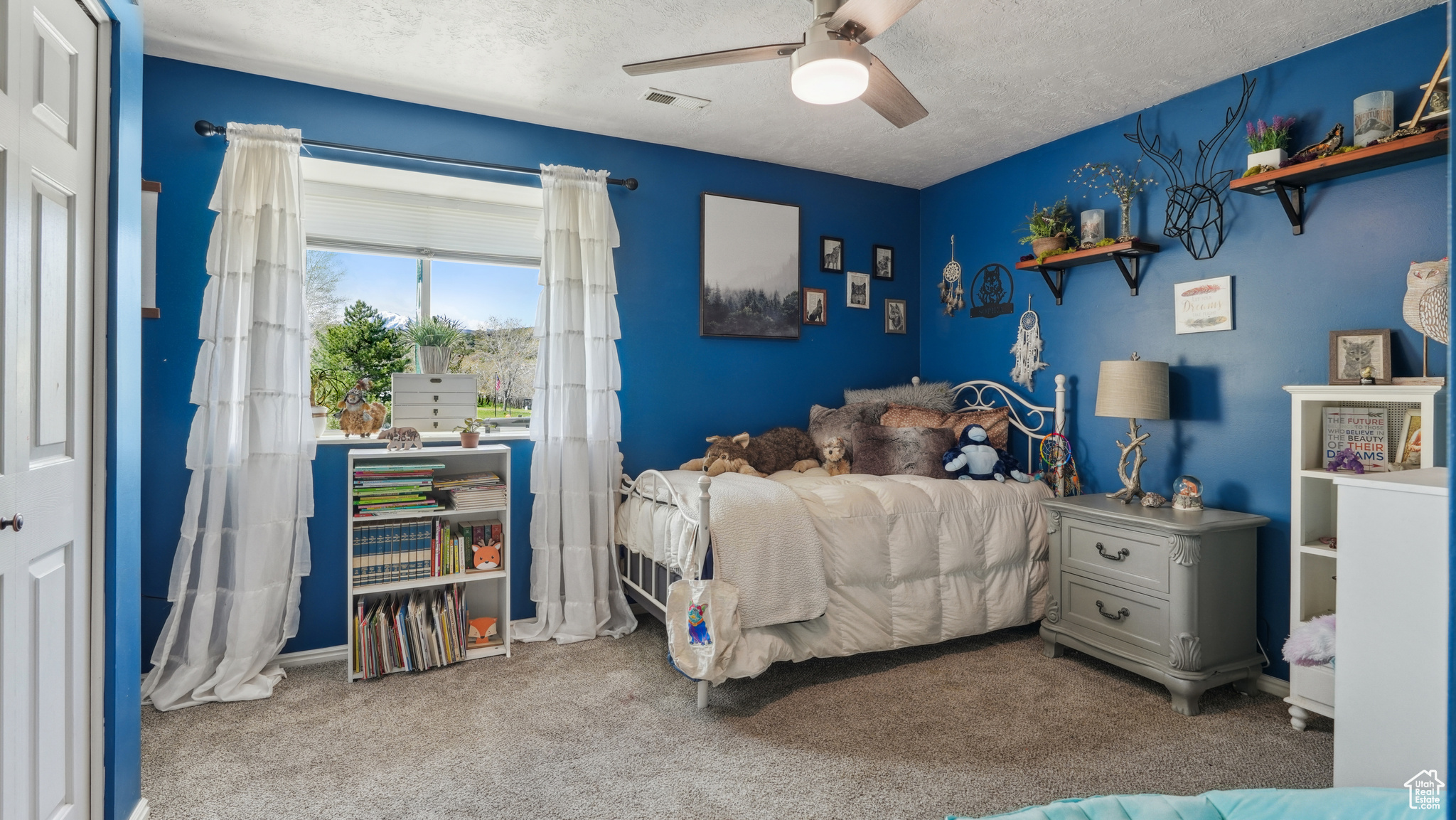 Bedroom with ceiling fan, carpet, and a textured ceiling