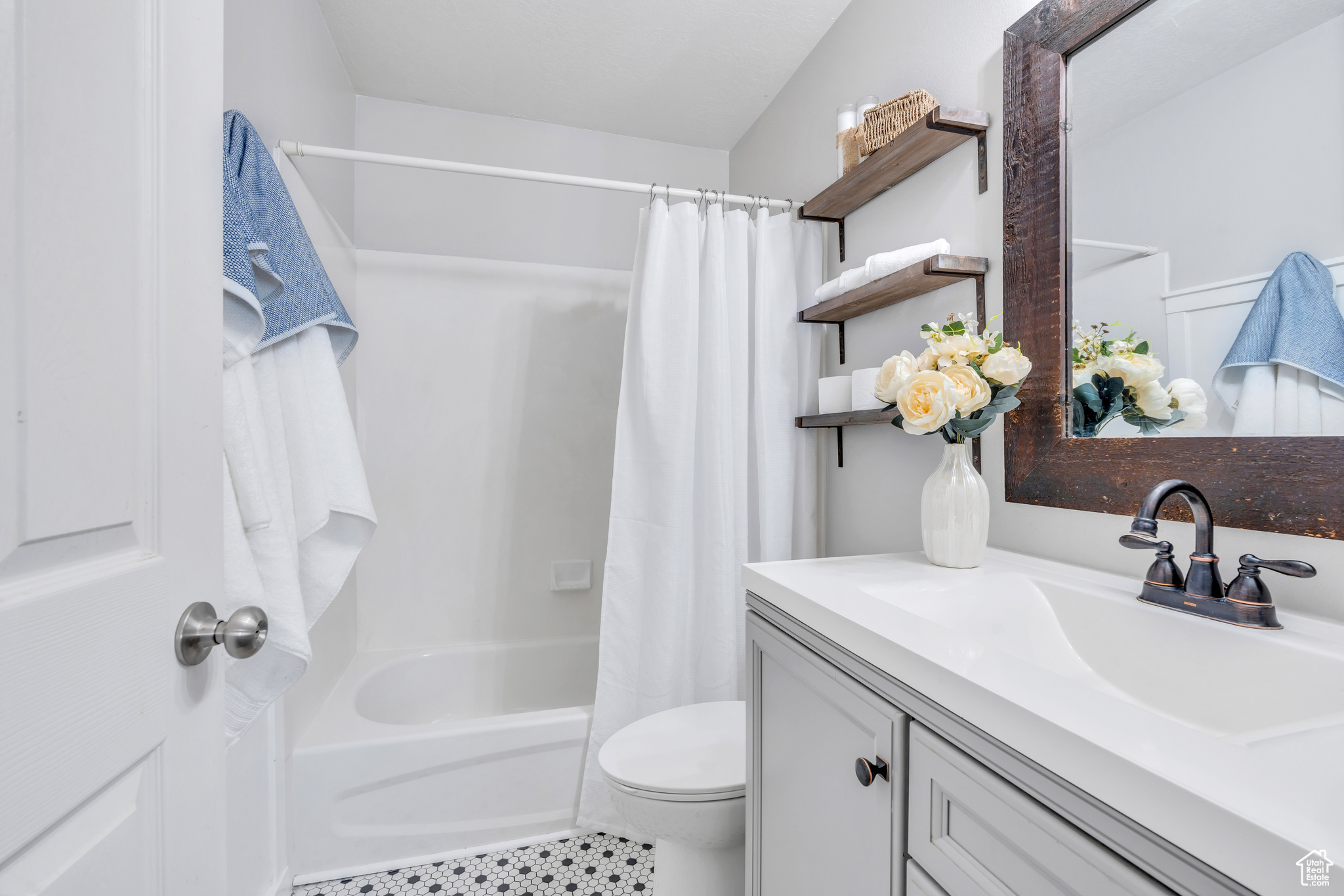 Full bathroom featuring tile flooring, shower / tub combo, toilet, vaulted ceiling, and vanity