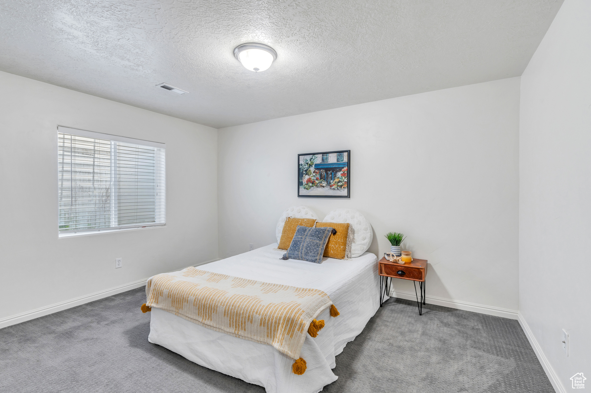 Bedroom featuring a textured ceiling and dark colored carpet