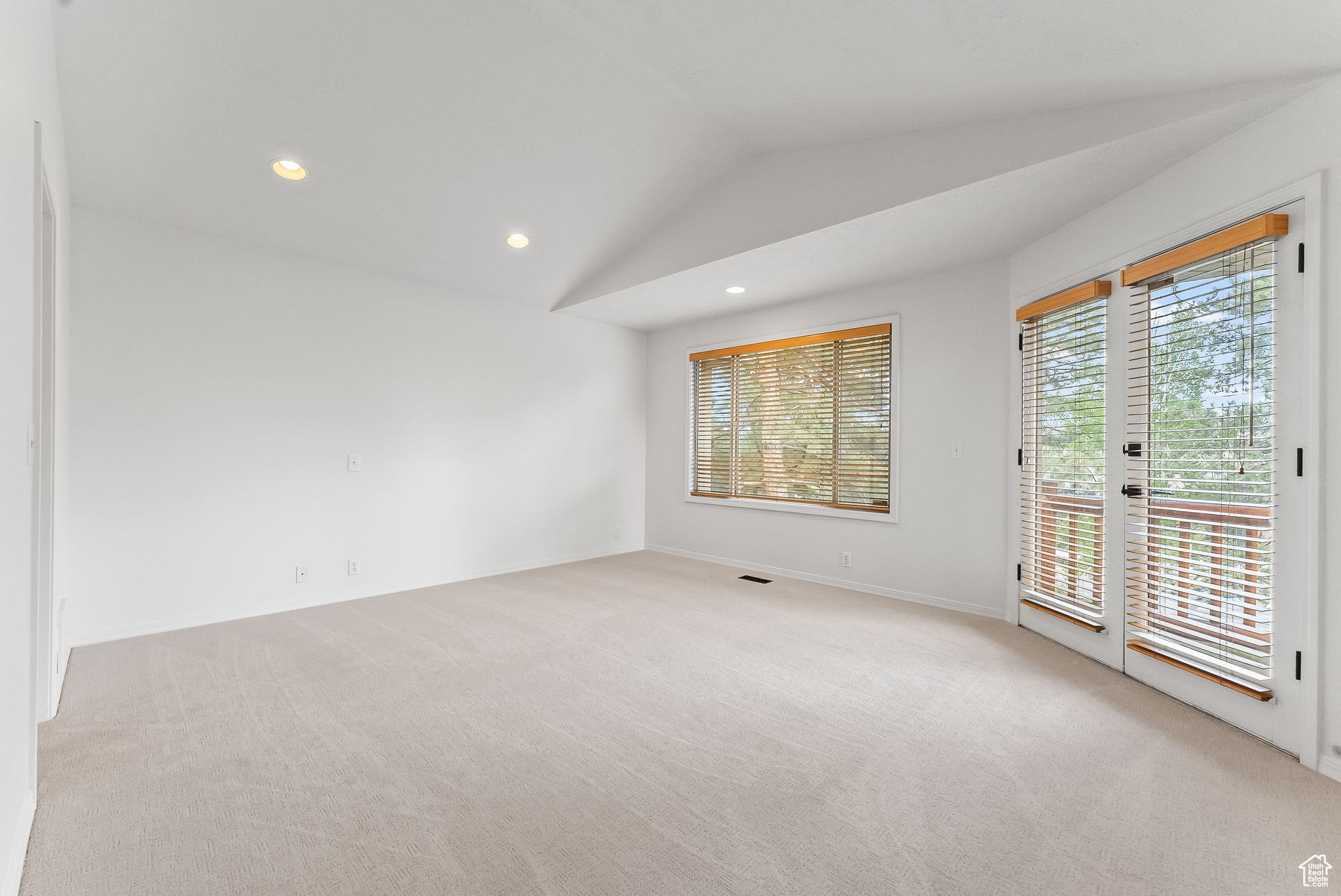 Master bedroom w/ french door leading to the balcony, lofted ceilings w/recessed lighting