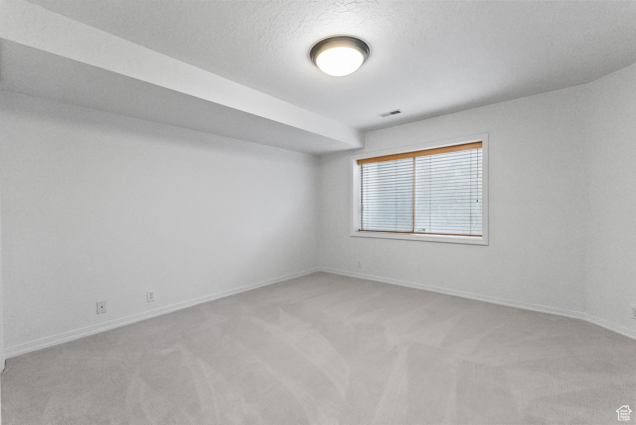 Carpeted spare room with a textured ceiling