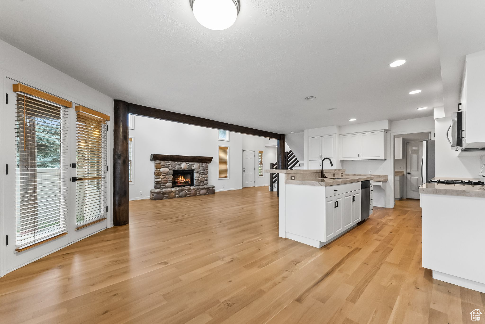 Kitchen with white cabinets, Stainless steel appliances, and light wood-type flooring