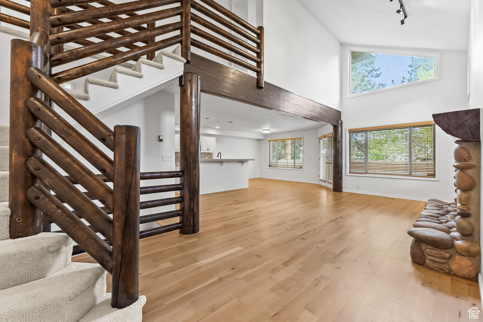 Warm and inviting livingroom featuring vaulted ceilings, light hardwood floors, vaulted ceiling and river rock fireplace.