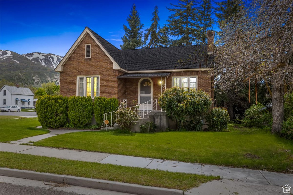 View of front of house with a front lawn and a mountain view