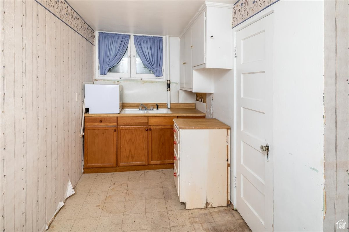 Kitchenette with sink and light tile flooring