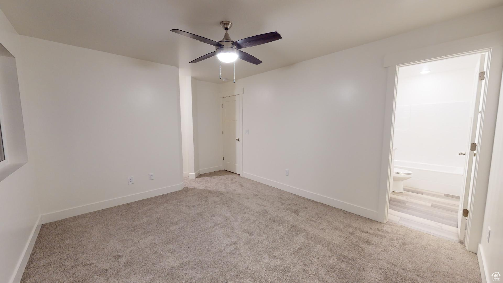 Carpeted spare room with ceiling fan