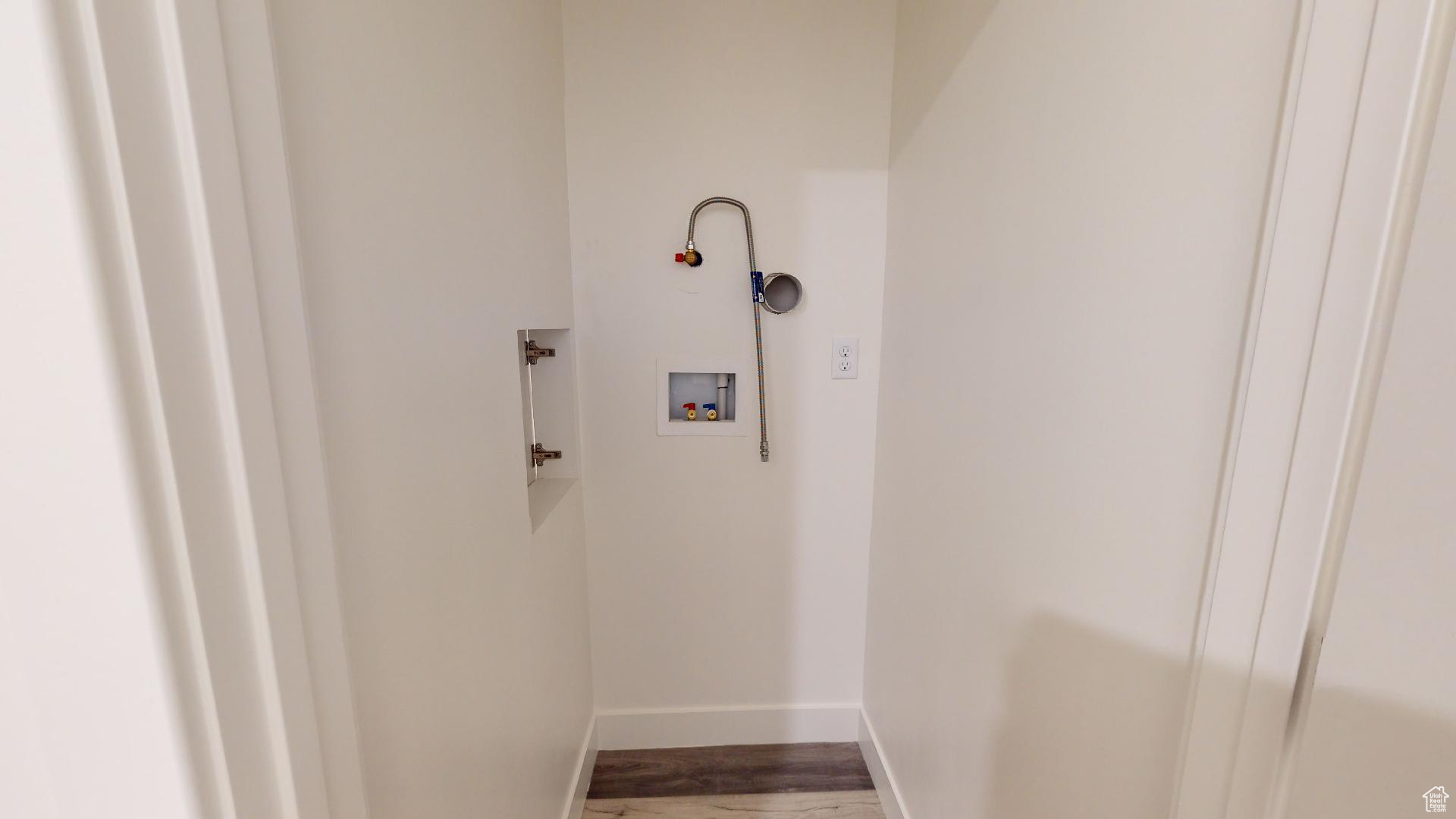 Clothes washing area with hardwood / wood-style flooring and washer hookup