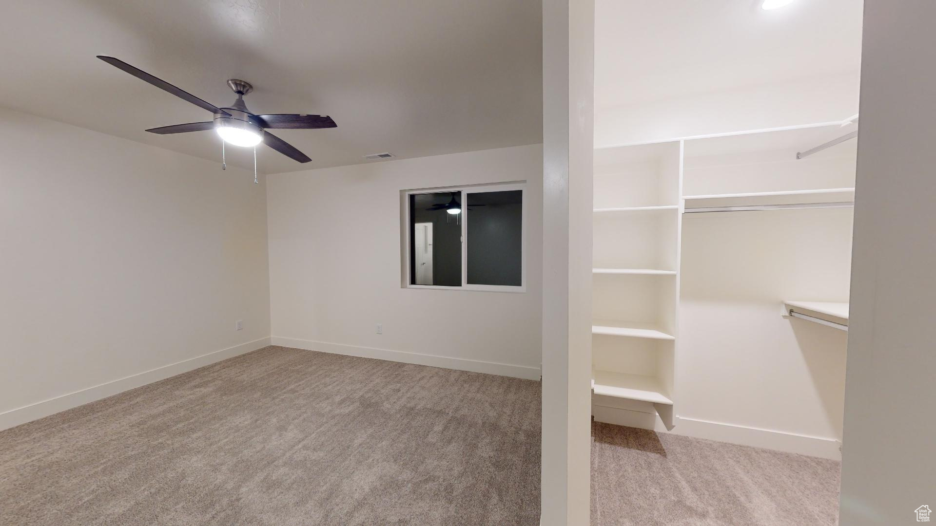 Interior space with ceiling fan and carpet