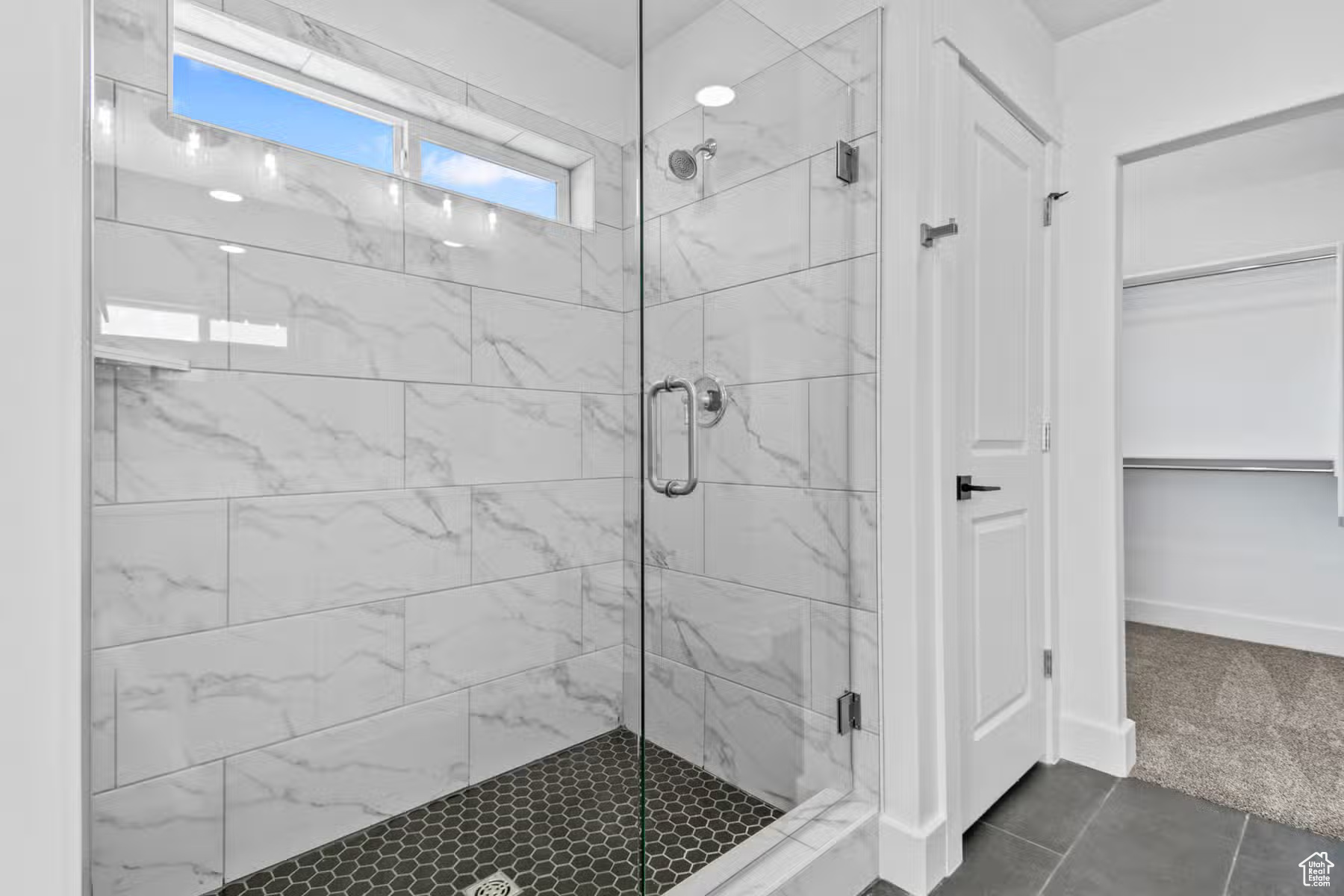 Bathroom with a shower with shower door and tile floors