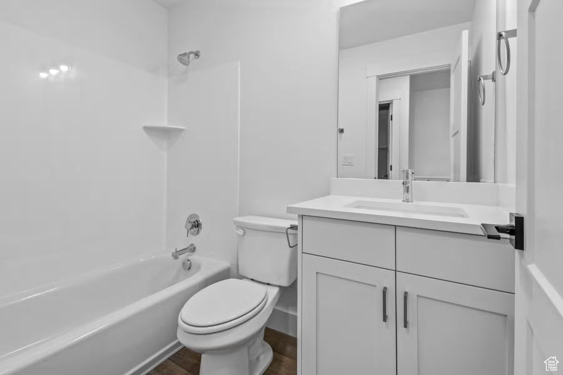 Full bathroom with tub / shower combination, hardwood / wood-style flooring, toilet, and vanity with extensive cabinet space