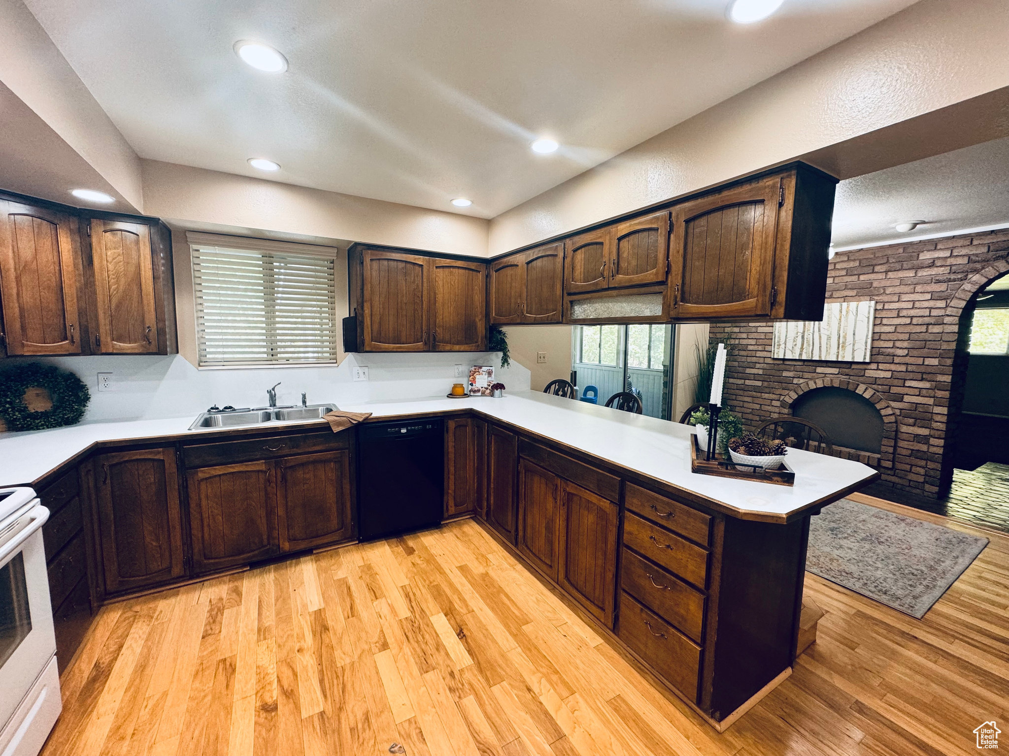 Spacious Kitchen with lots of cabinetry, a large desk and a beautiful brick wall