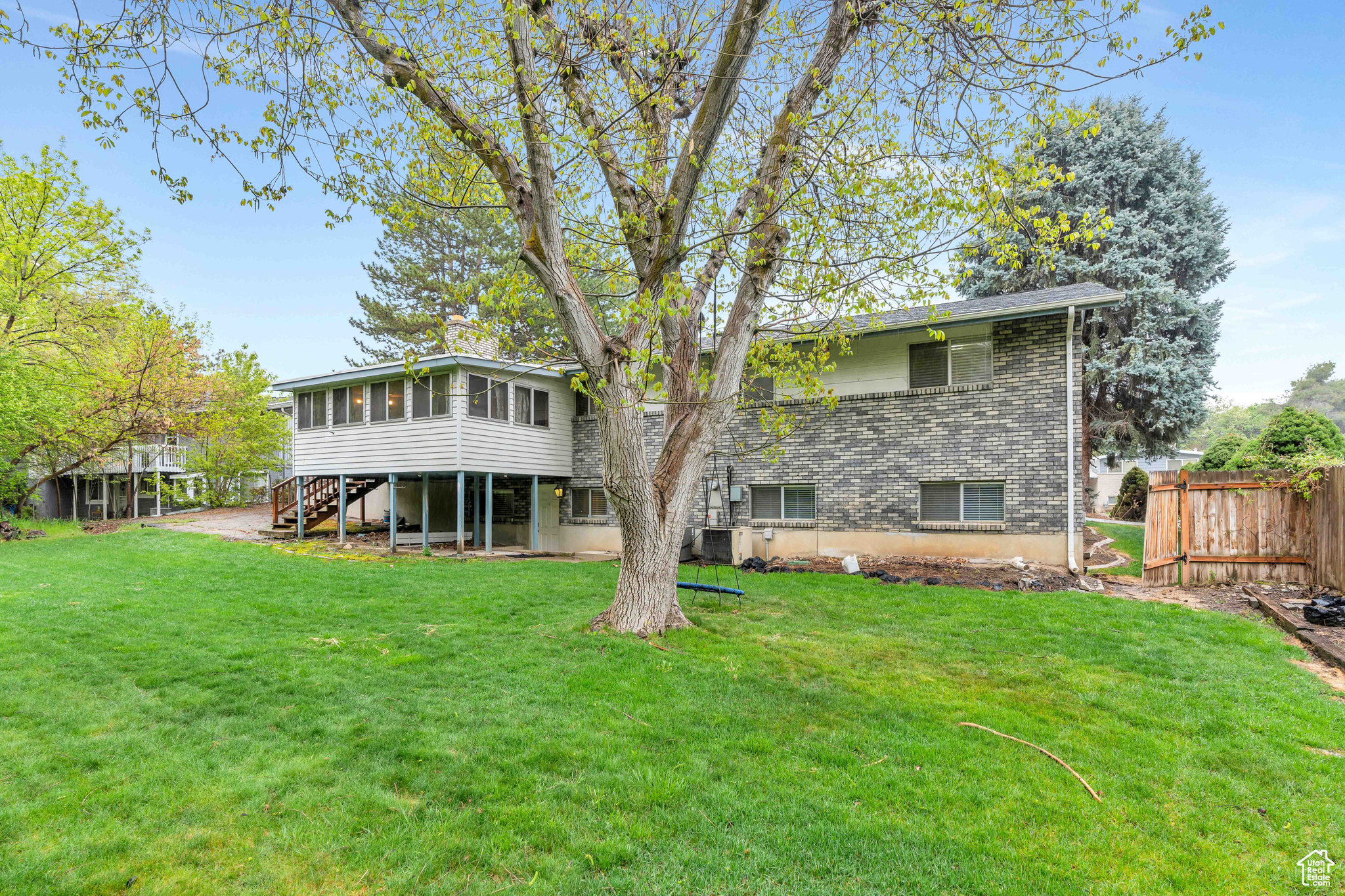 Rear view of property featuring a large lawn and the Sunroom