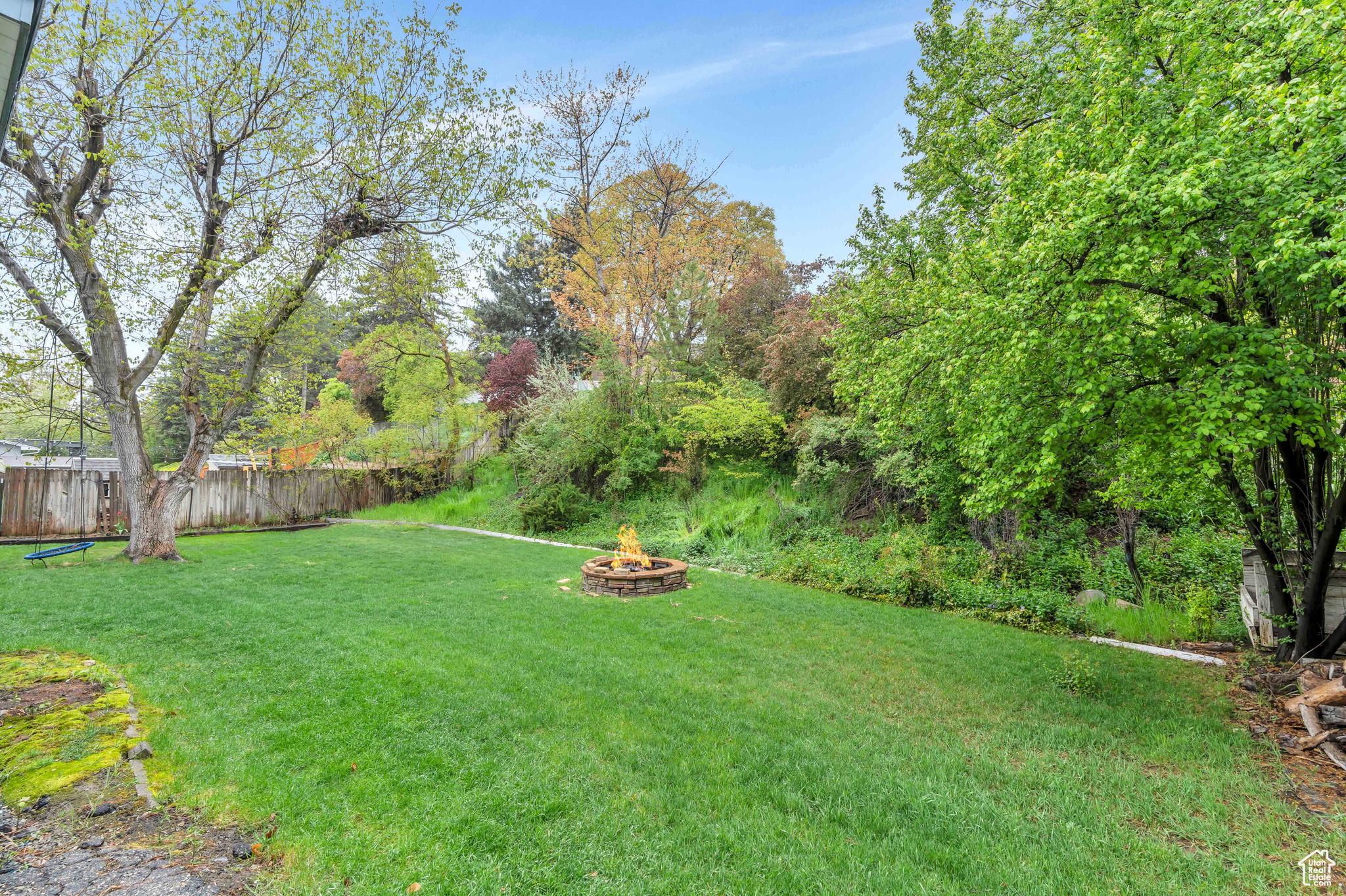 View of yard featuring an outdoor fire pit, many trees and a beautiful view