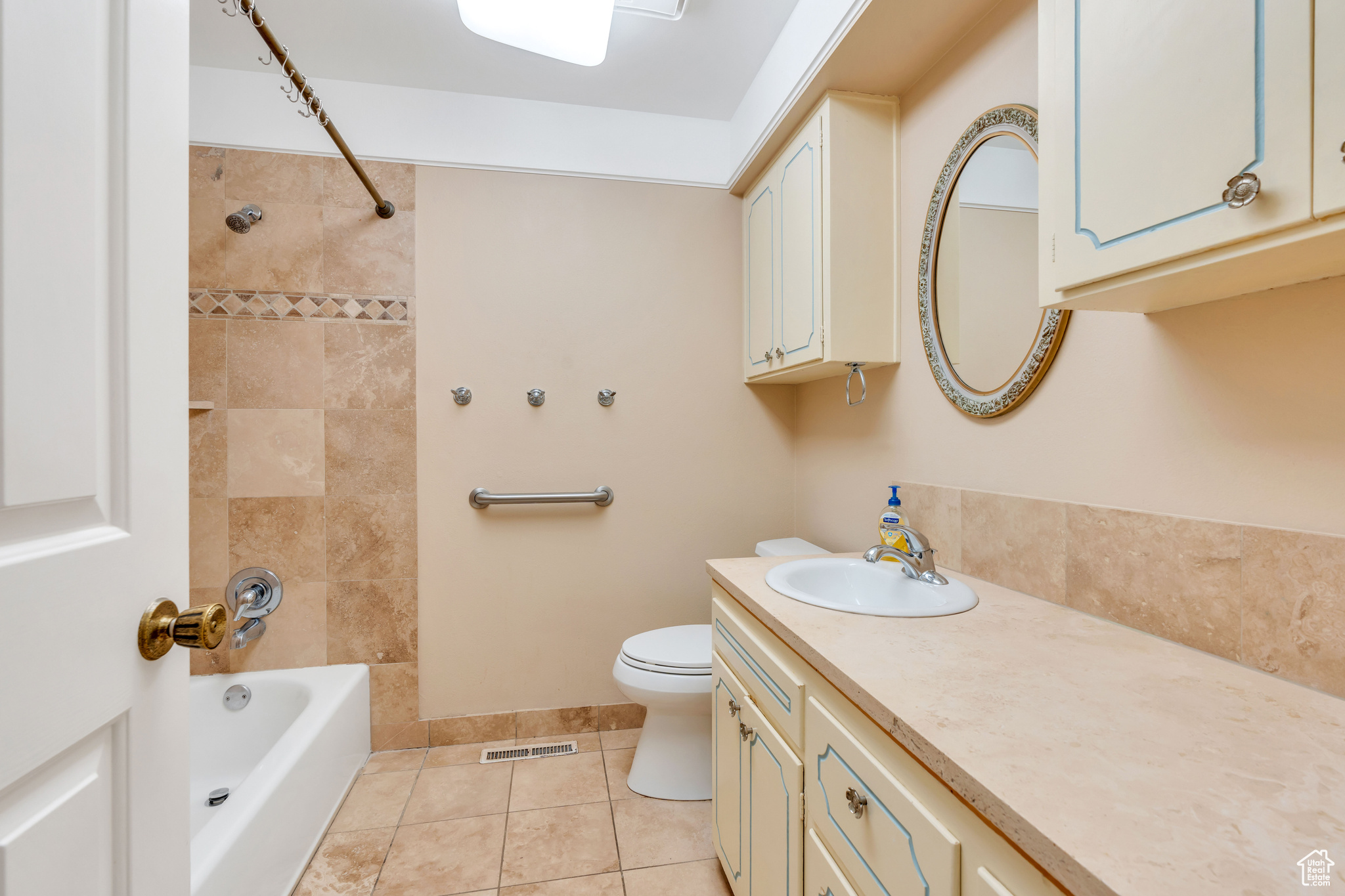 Full Bath featuring tiled shower / bath combo, vanity, tile floors, and toilet