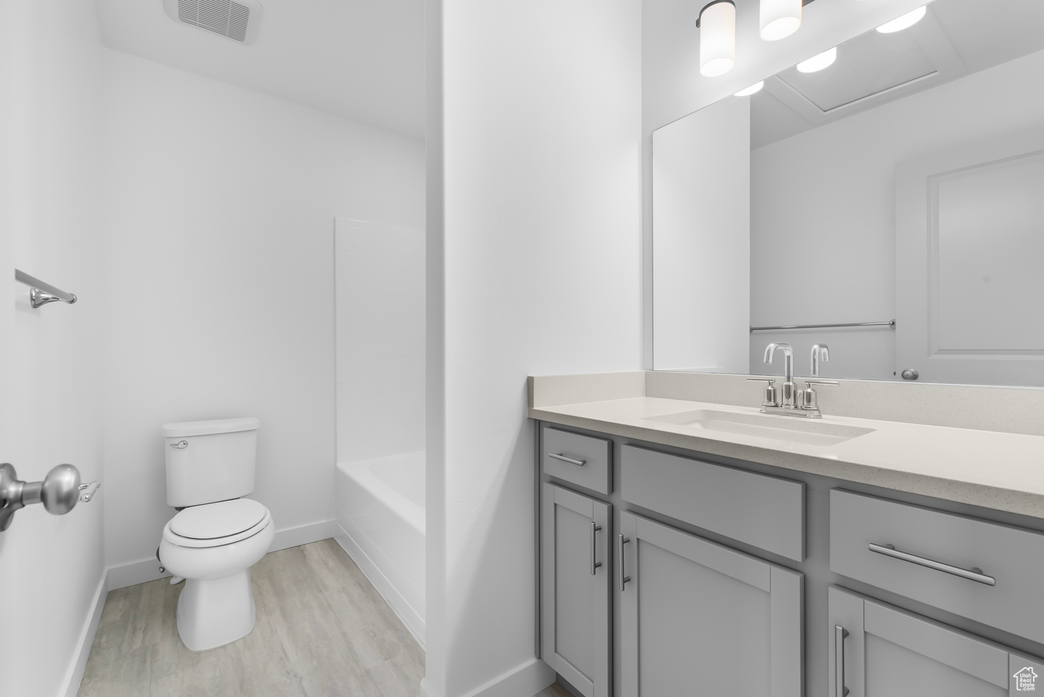 Full bathroom featuring wood-type flooring, shower / bath combination, vanity, and toilet