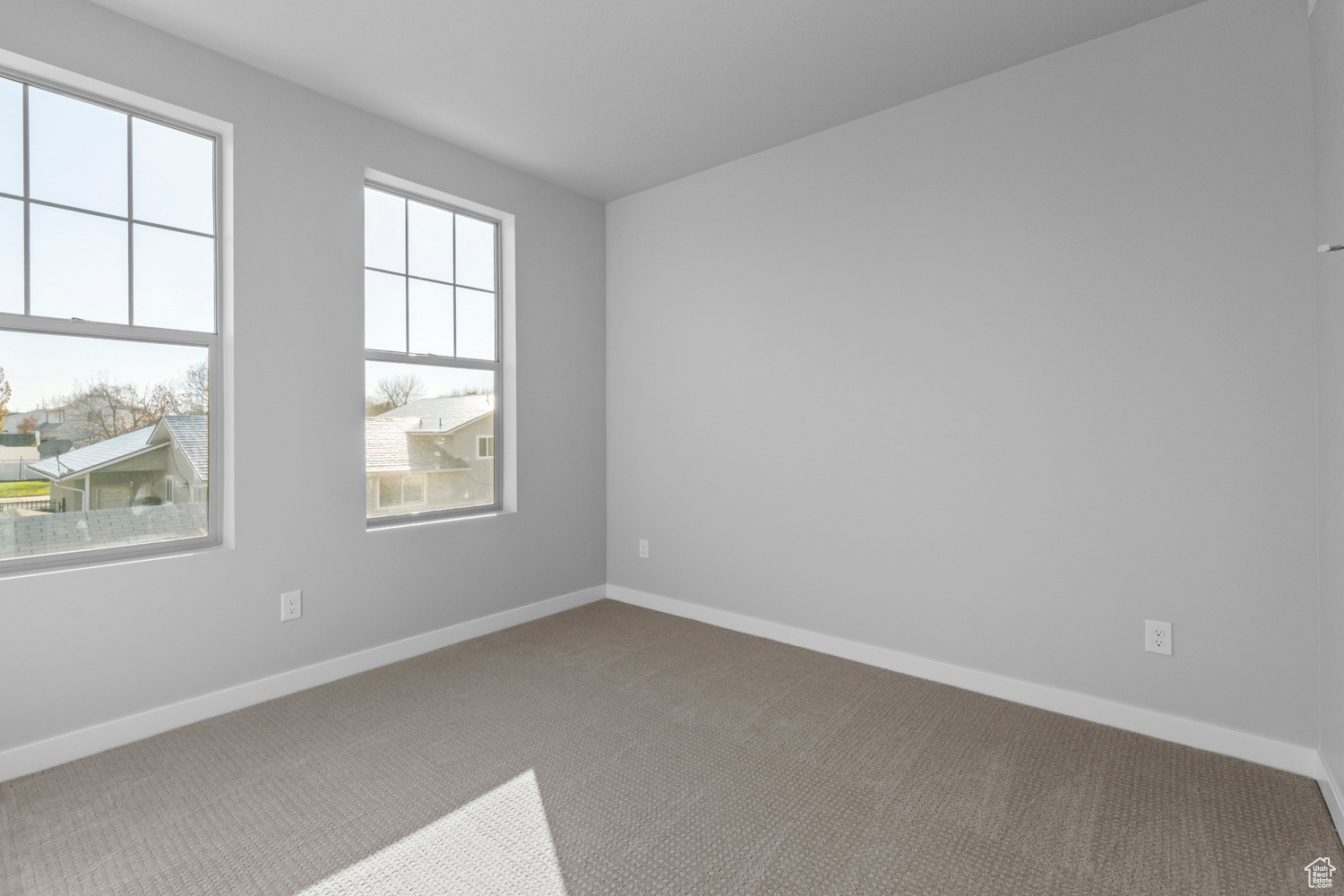 Carpeted empty room featuring plenty of natural light