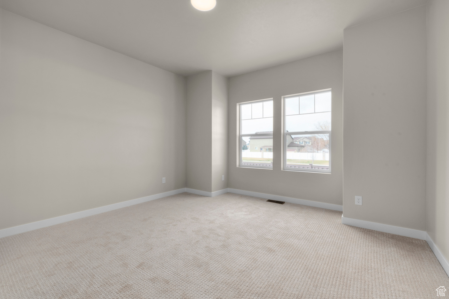 Empty room with light colored carpet