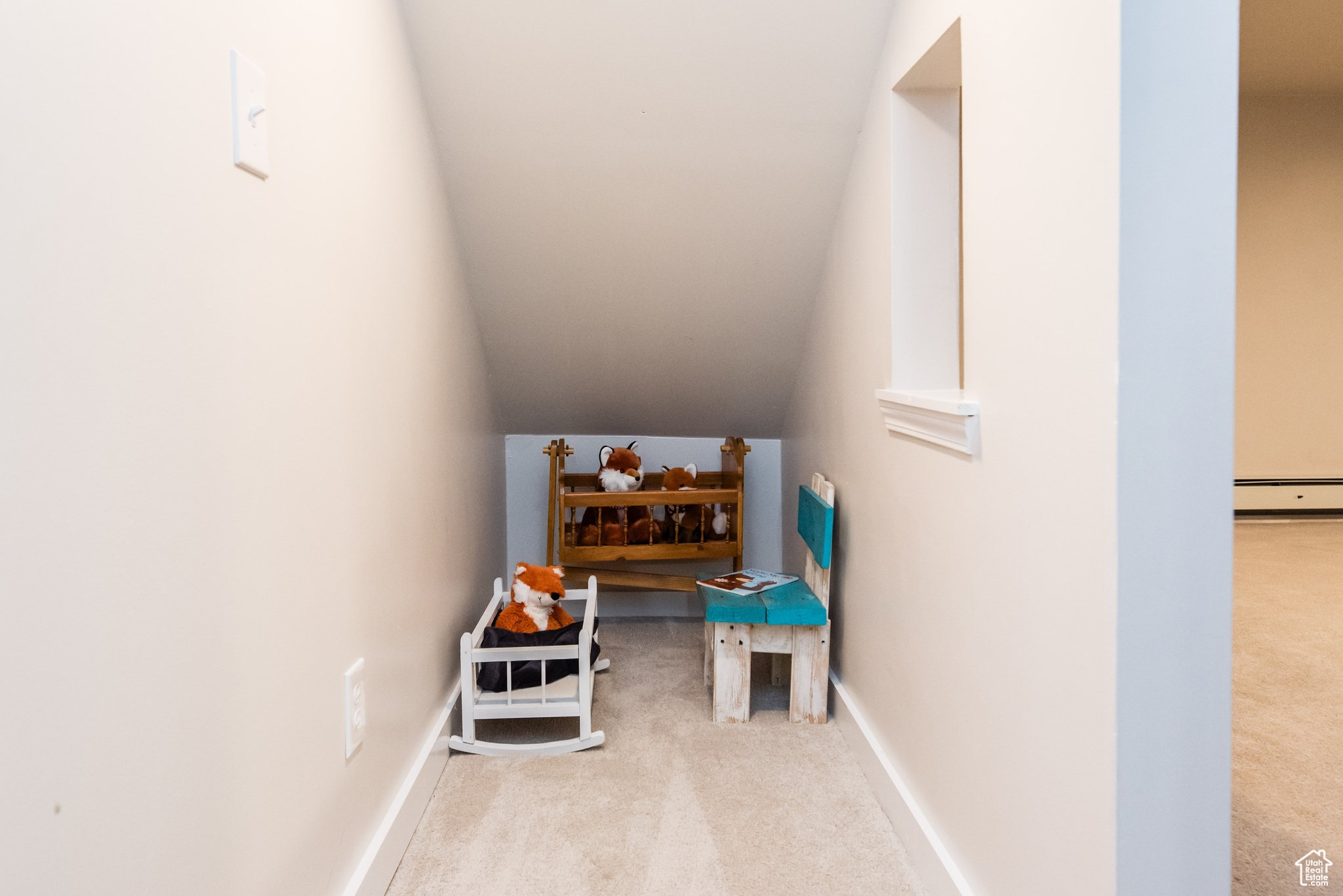 Rec room featuring light carpet, vaulted ceiling, and a baseboard radiator