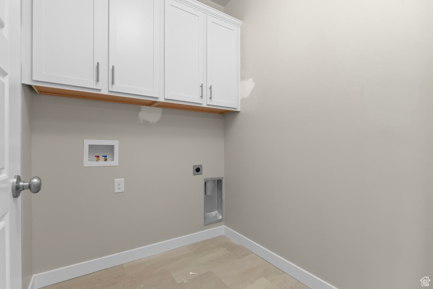Laundry room with hookup for a washing machine, light hardwood / wood-style flooring, electric dryer hookup, and cabinets