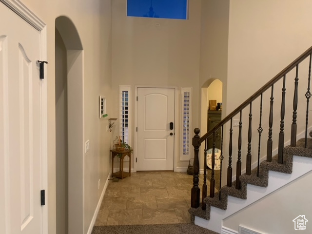 Foyer with tile floors and a towering ceiling