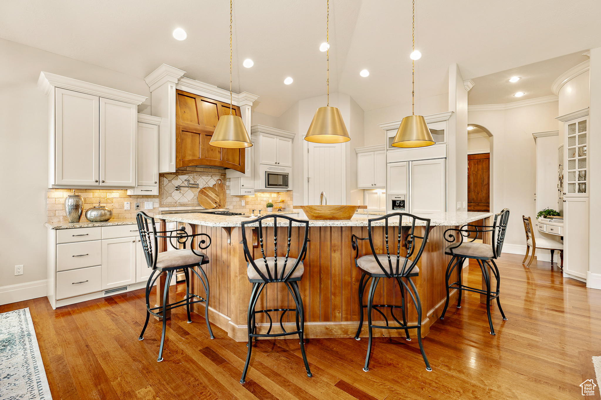 Kitchen with light hardwood / wood-style flooring, tasteful backsplash, a large island, and light stone countertops
