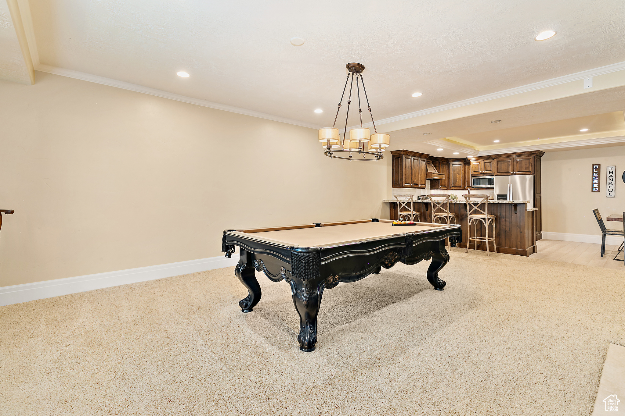 Game room featuring light colored carpet, billiards, a tray ceiling, and ornamental molding
