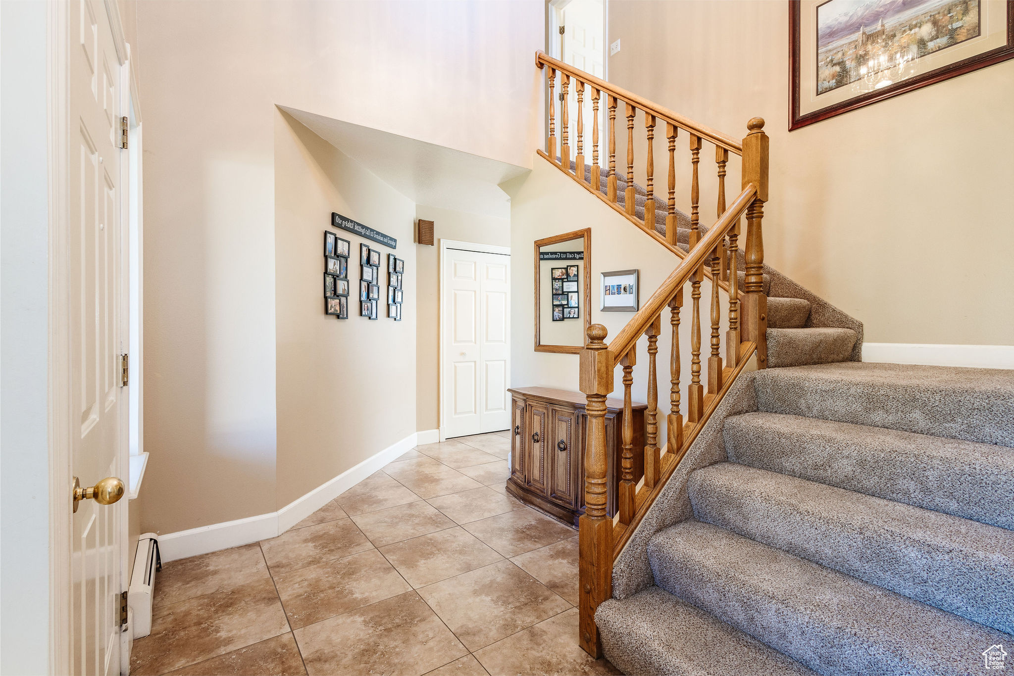 Tiled foyer with a high ceiling and baseboard heating