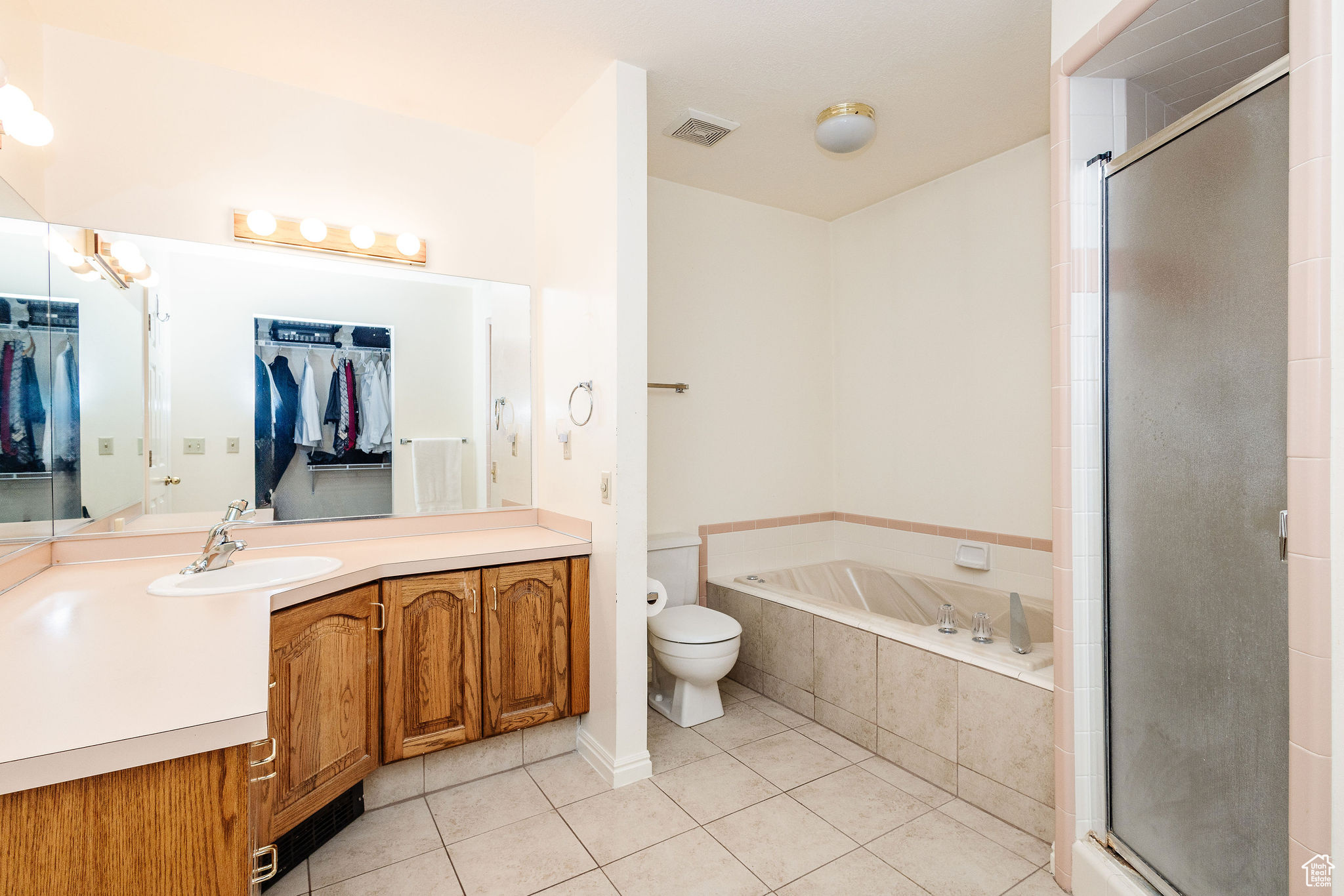Full bathroom featuring tile flooring, vanity, separate shower and tub, and toilet