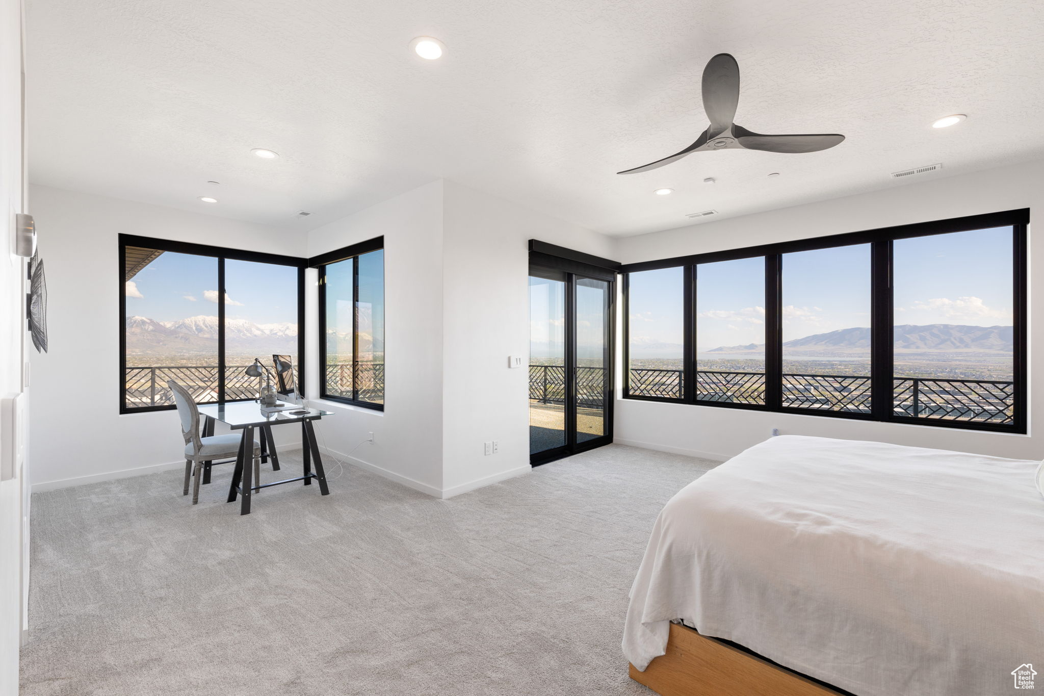 Bedroom featuring a mountain view, ceiling fan, light carpet, and access to exterior