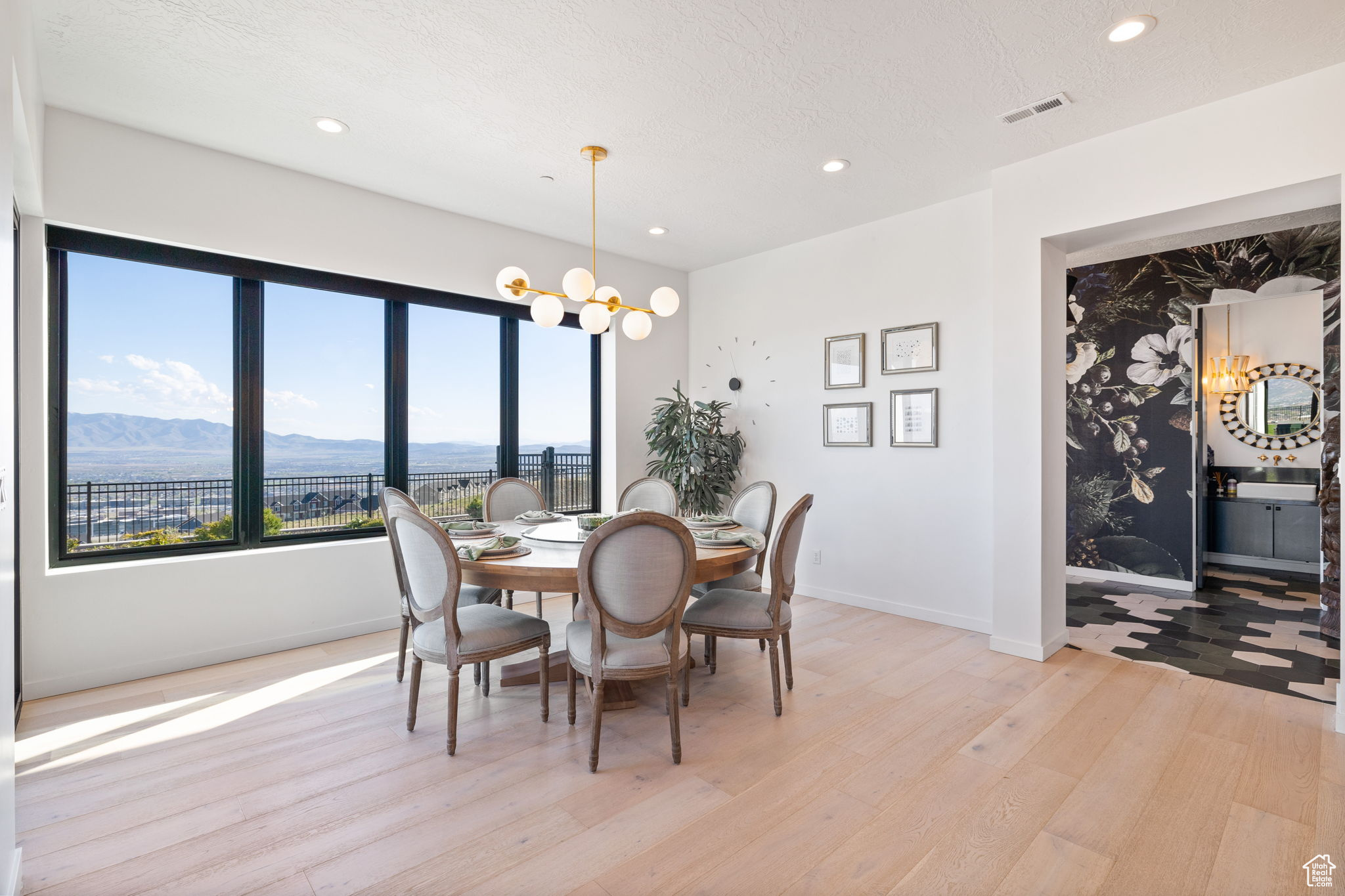 Dining area with a mountain view, light hardwood / wood-style floors, and a notable chandelier