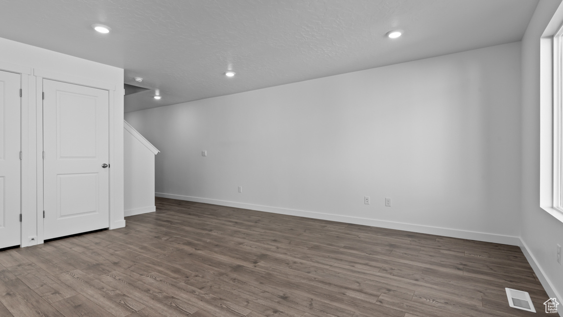 Spare room with dark hardwood / wood-style flooring and a textured ceiling