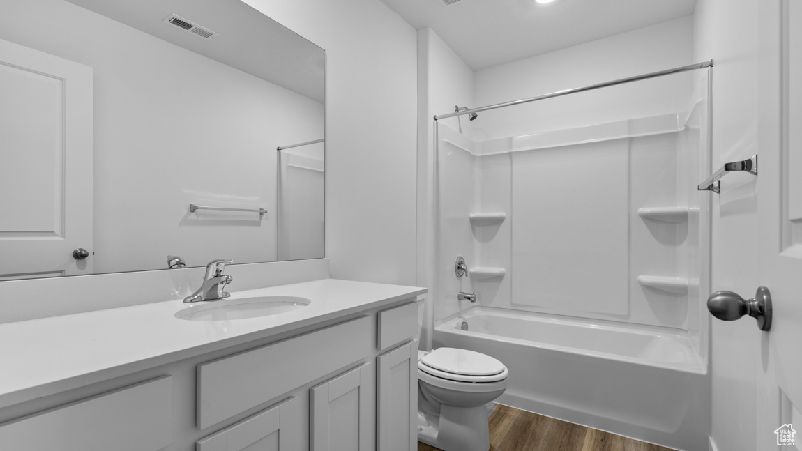 Full bathroom featuring vanity, hardwood / wood-style flooring, toilet, and bathing tub / shower combination