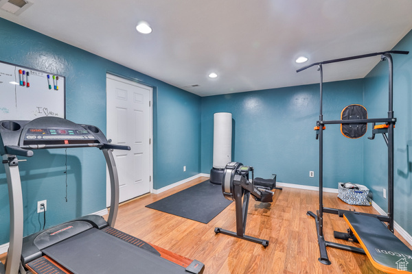 Workout room with wood-type flooring