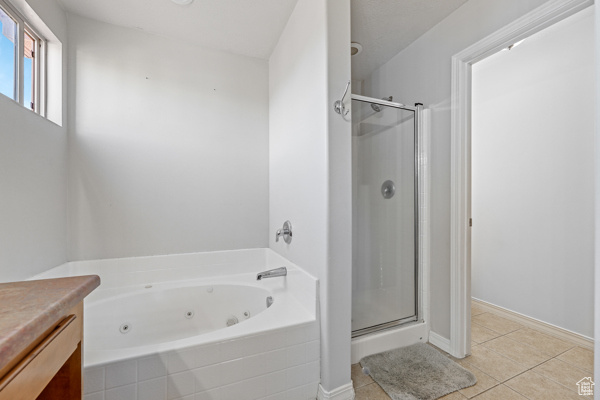 Bathroom featuring shower with separate bathtub and tile floors!