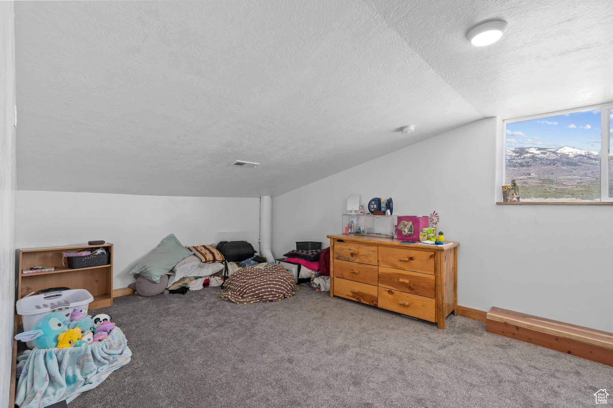 Playroom featuring a textured ceiling, vaulted ceiling, and carpet flooring