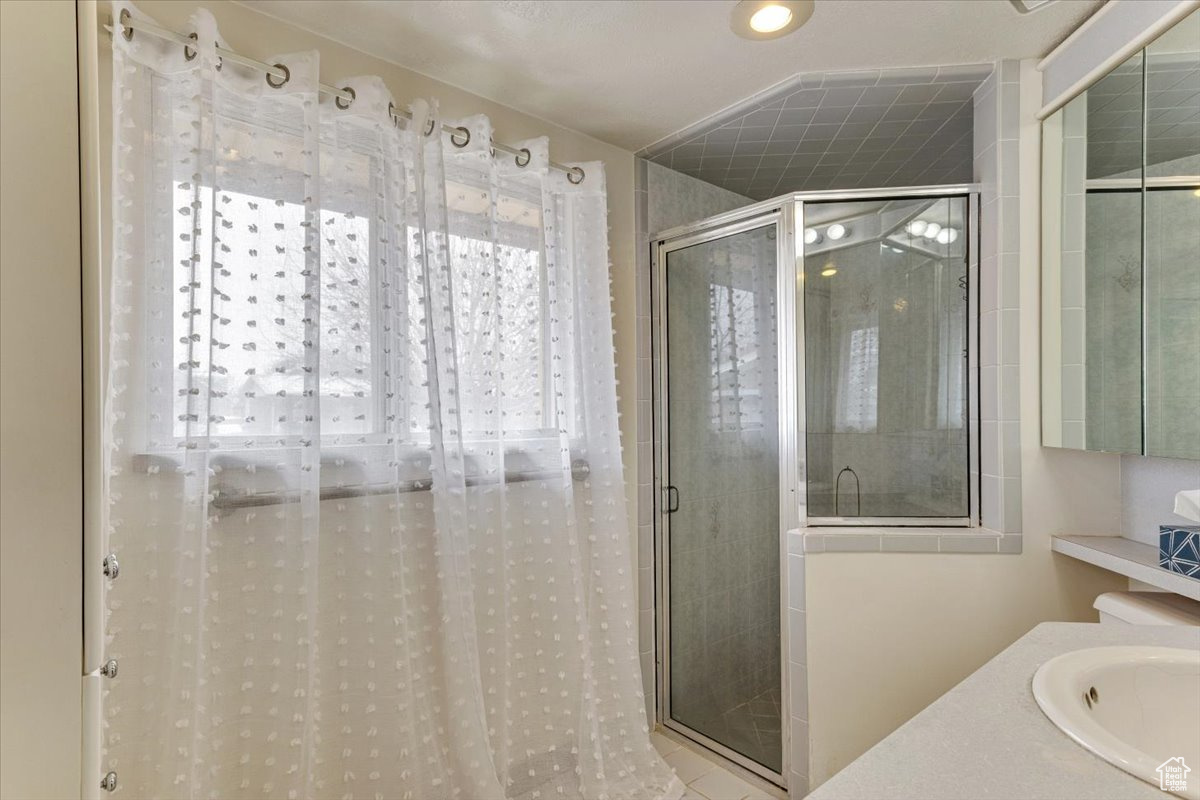 Bathroom featuring plenty of natural light, an enclosed shower, and sink