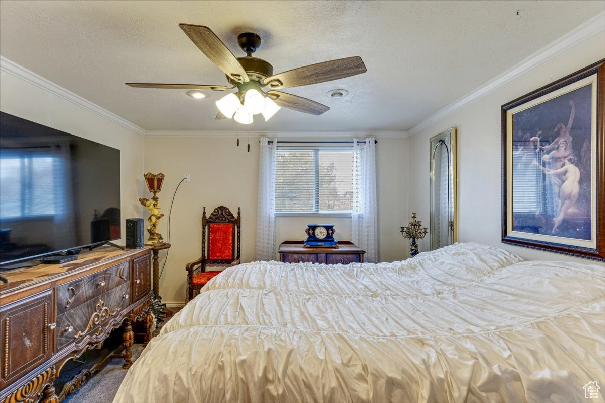 Bedroom with ornamental molding and ceiling fan