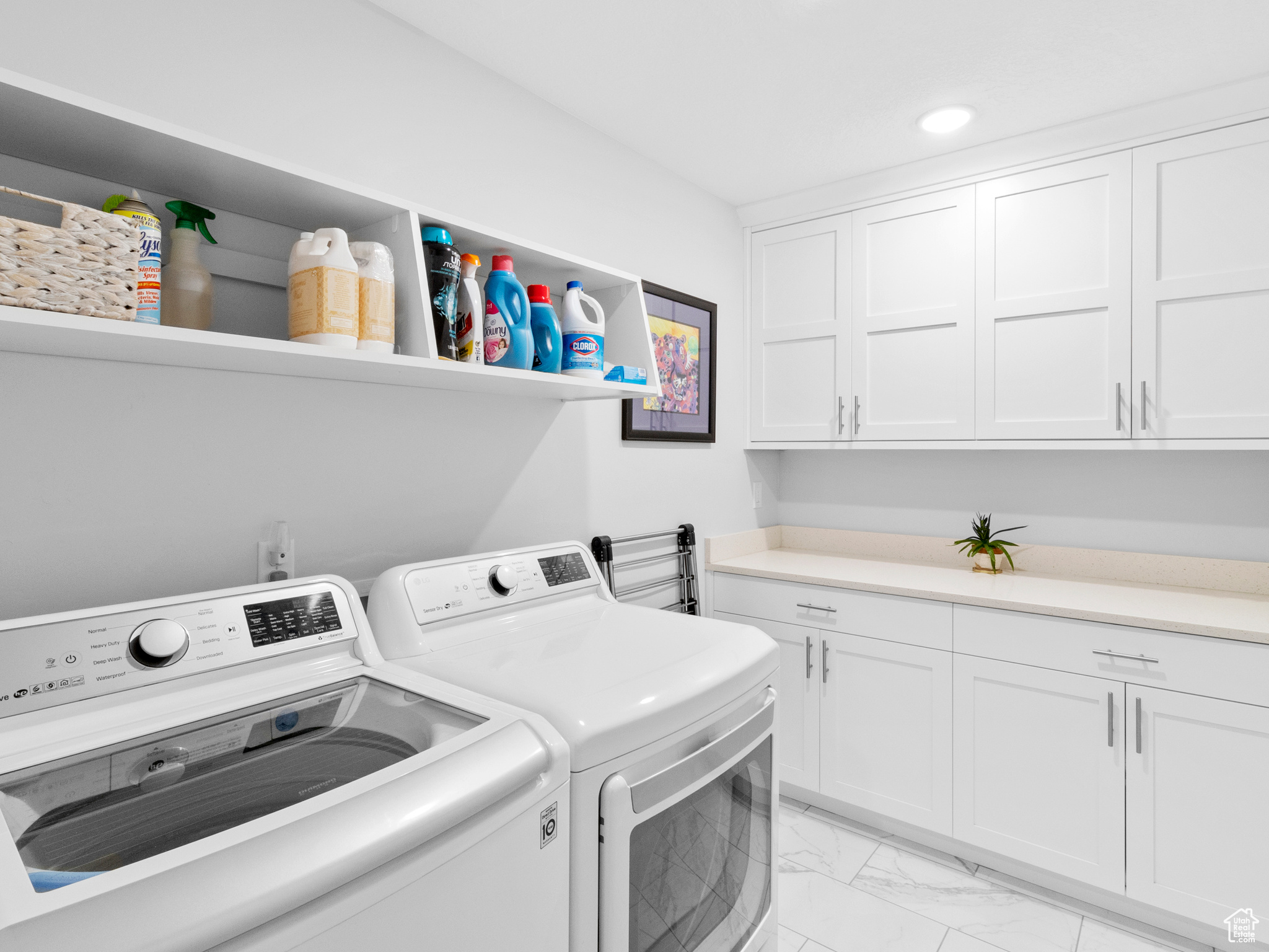 Laundry area featuring cabinets, separate washer and dryer, and light tile floors