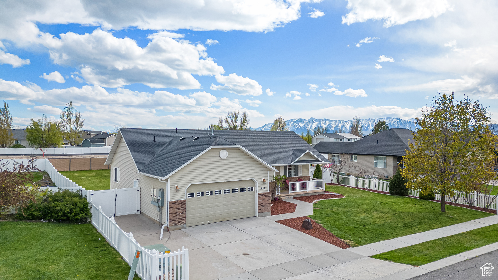 View of front of home featuring a front yard, a mountain view, and a garage