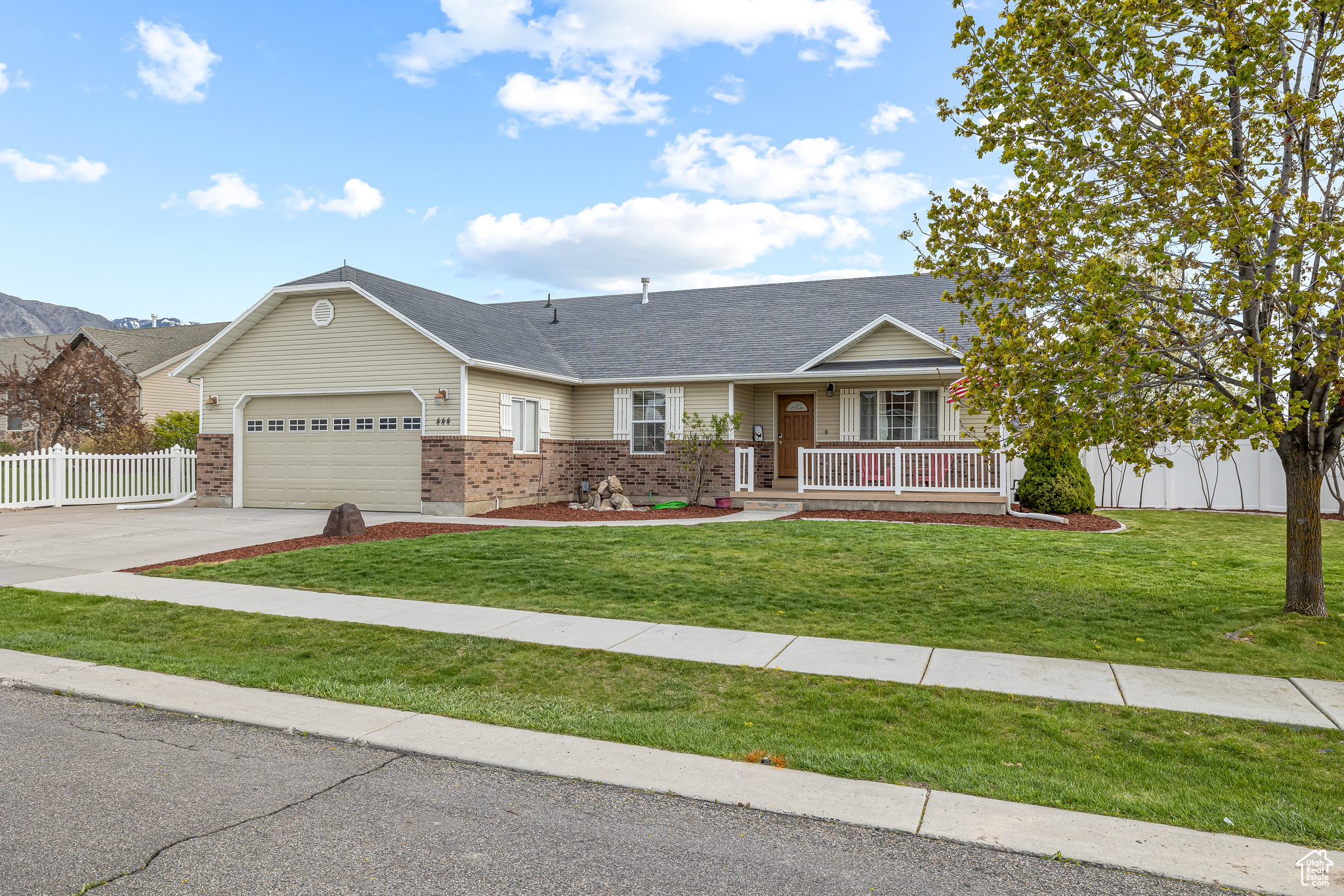 Single story home featuring a front yard, a porch, and a garage