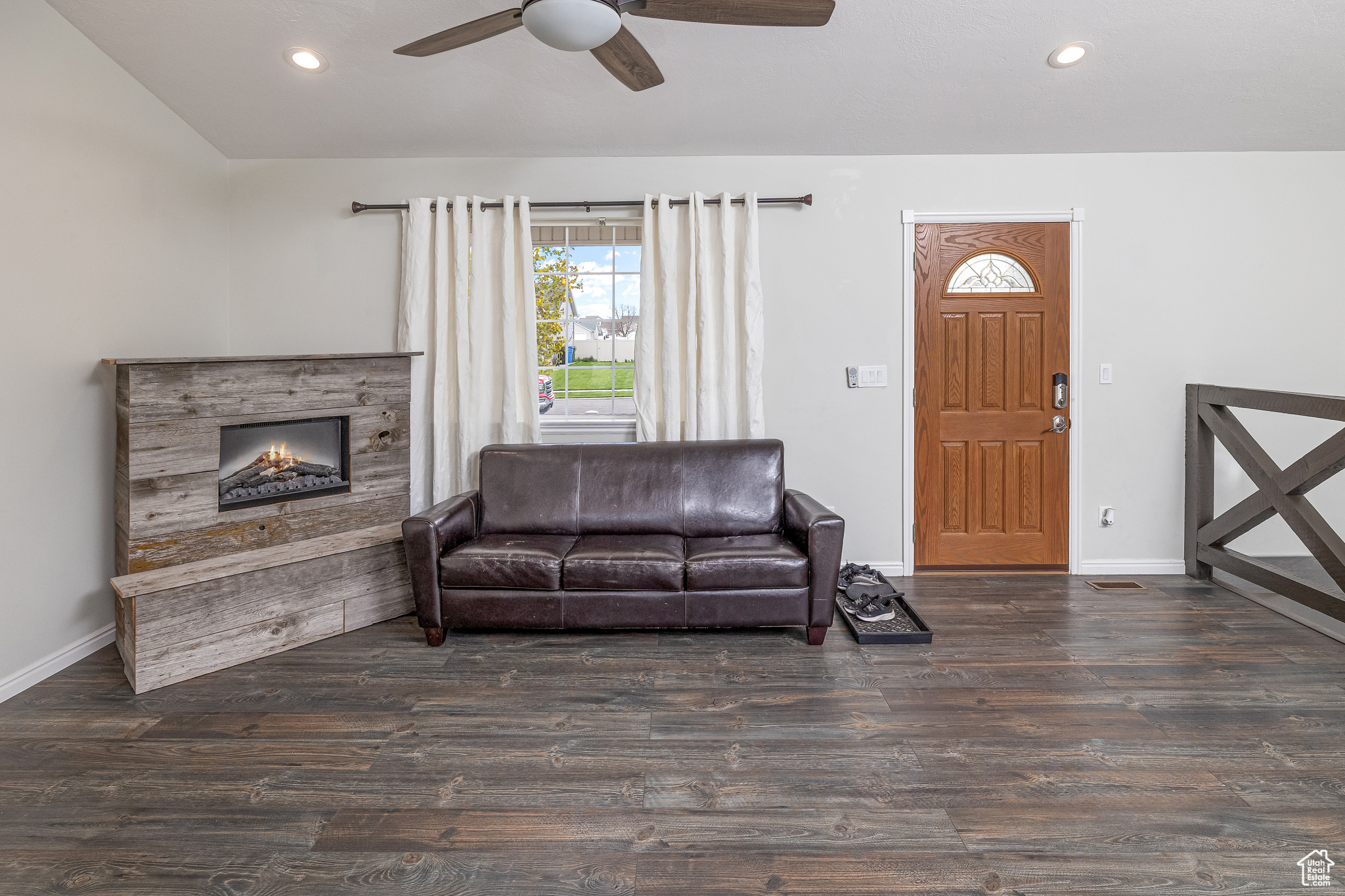 Living room with ceiling fan, dark hardwood / wood-style floors.