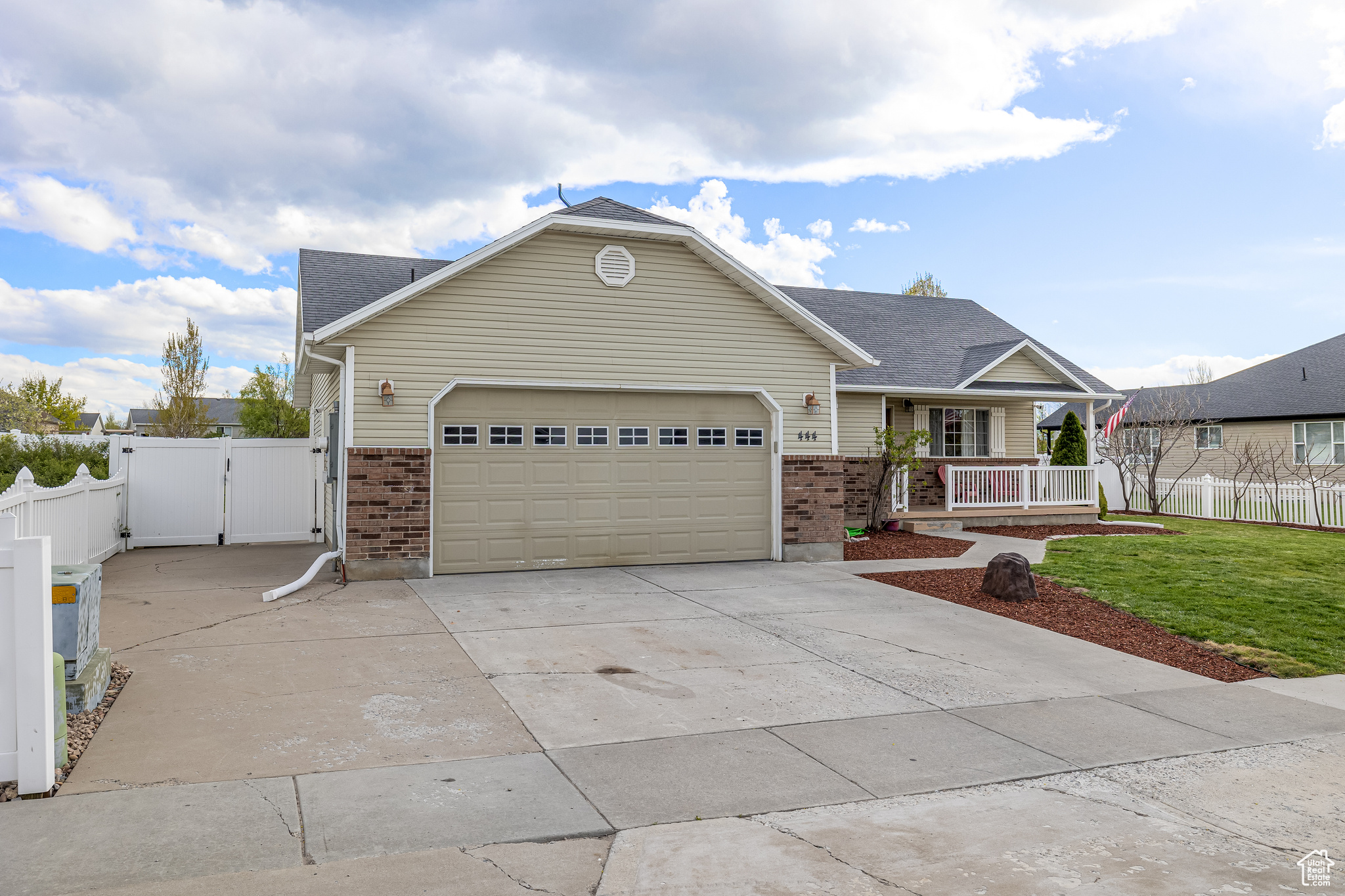 View of front of house with a garage, a porch, and a front yard