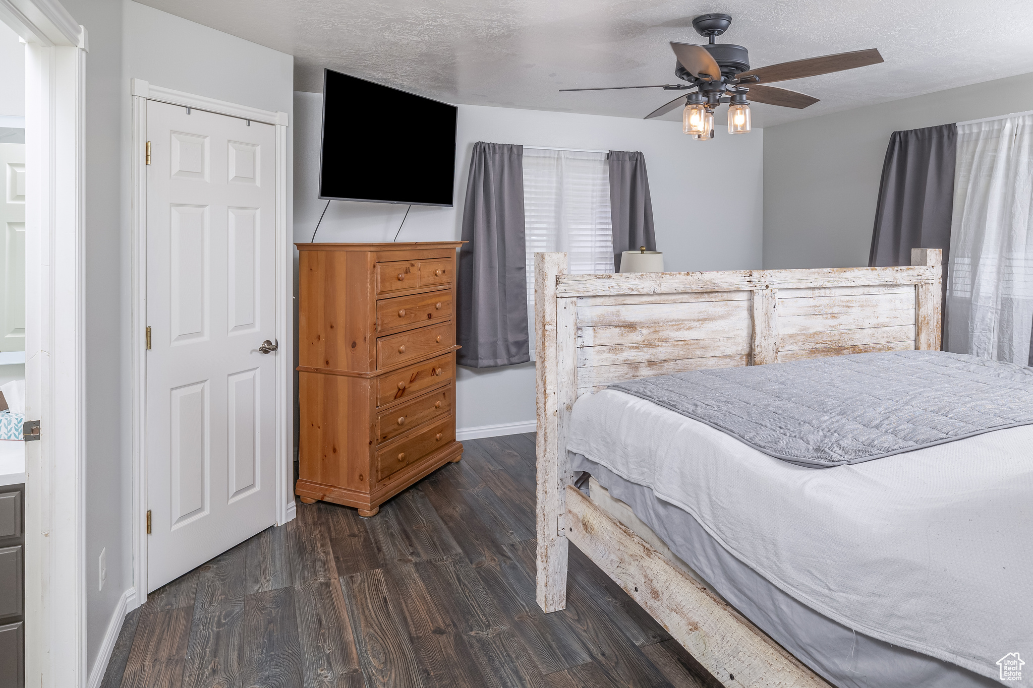 Primary bedroom featuring a closet, dark wood-type flooring, and ceiling fan