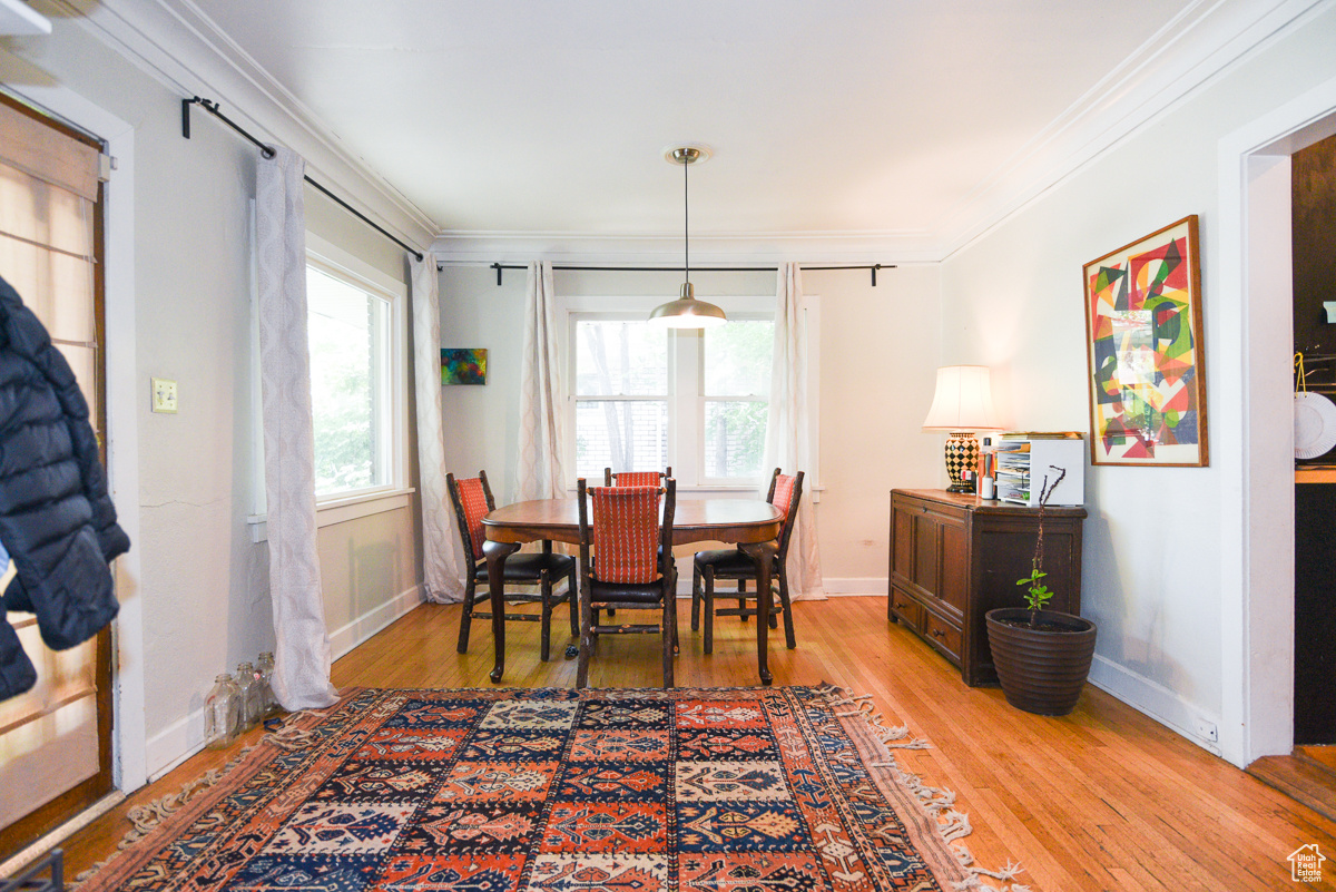 Dining space with hardwood / wood-style flooring and crown molding