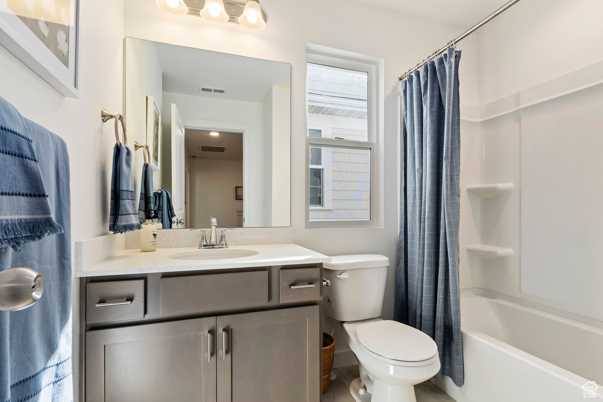 Full bathroom featuring shower / bathtub combination with curtain, toilet, tile flooring, and large vanity