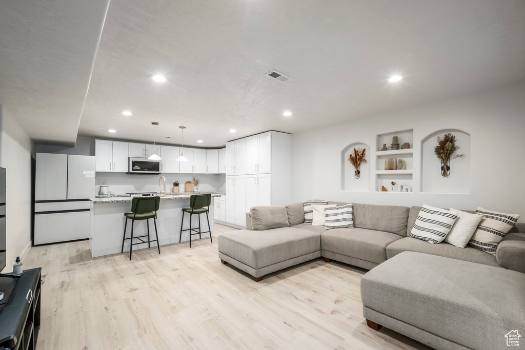 Living room featuring sink and light hardwood / wood-style floors