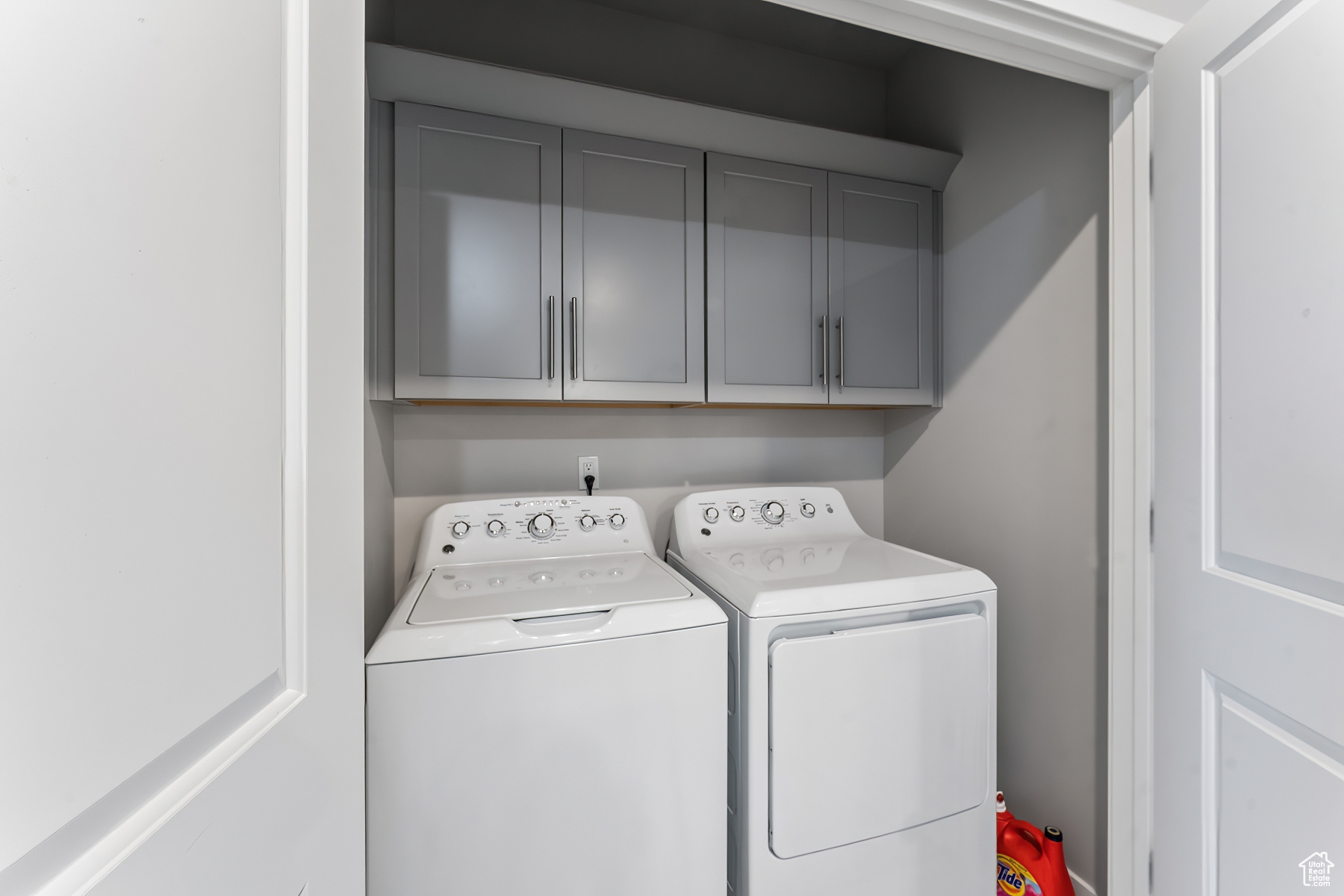 Clothes washing area with cabinets and washer and dryer